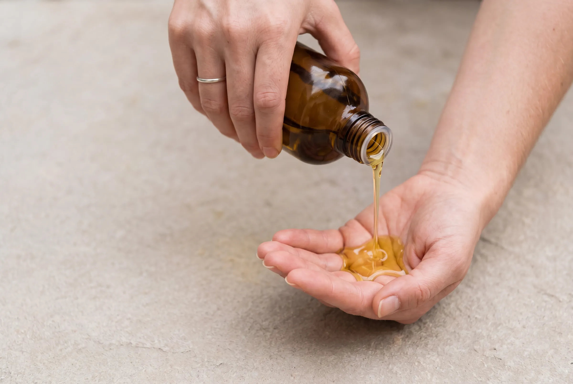 Aceite de masaje Ikonoverde vertido en la palma de una mano